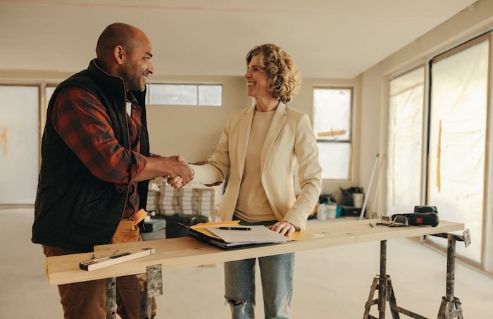 Restoration contractor shaking hands with homeowner client. 