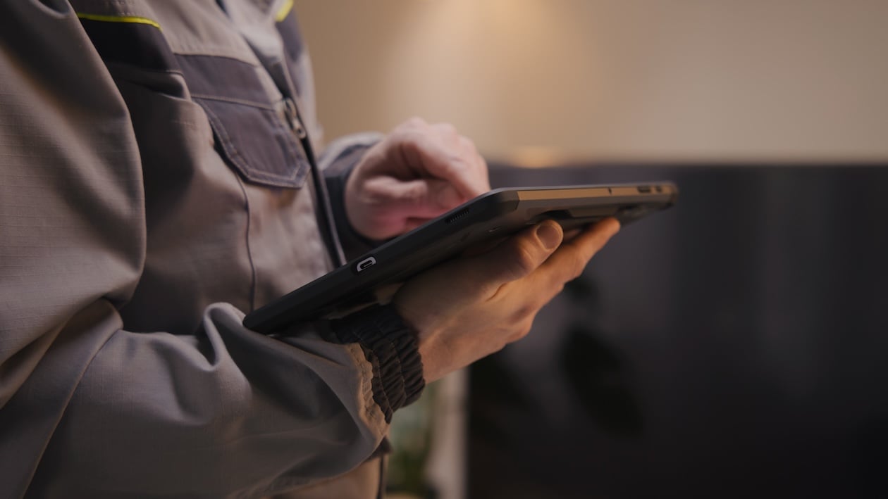 Restoration technician using a tablet to document job site work and update project information for insurance claim reporting.