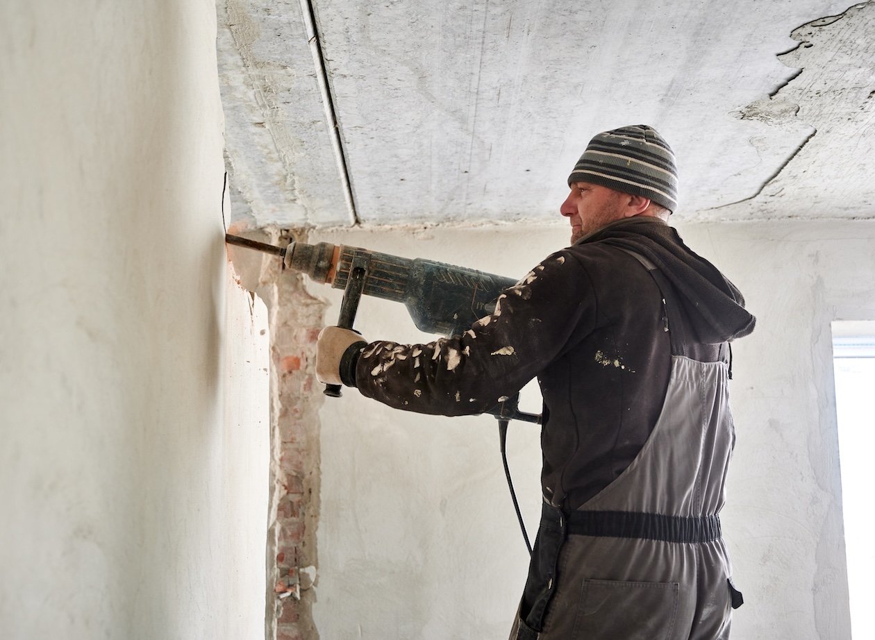 Restoration worker removing damaged wall.