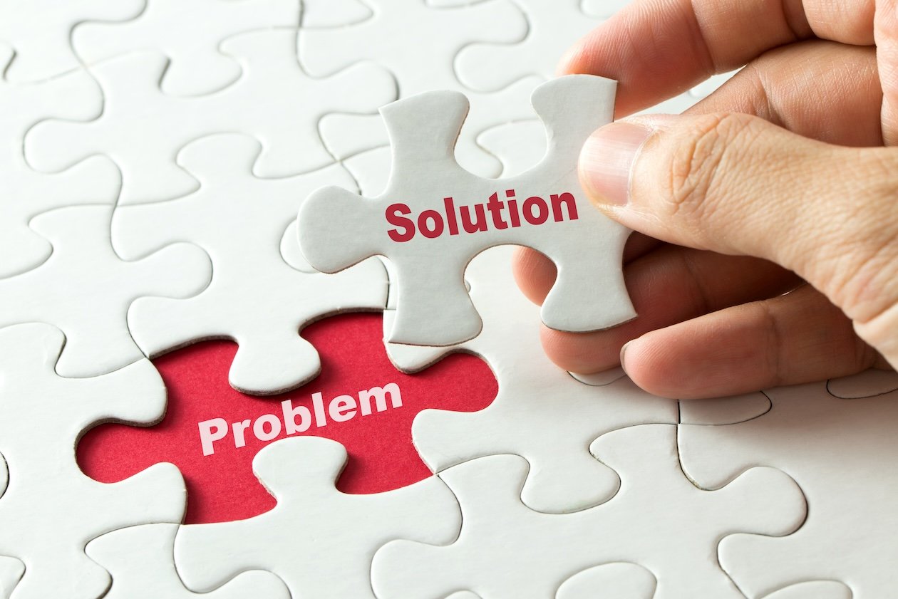 Hand placing a puzzle piece labeled “Solution” into a gap labeled “Problem,” representing identifying operational issues and implementing systems to fix inefficiencies in a growing restoration business